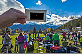 The partial solar eclipse of October 23, 2014 as seen from Jasper, Alberta, at a public event in Centennial Park as part of the annual Dark Sky Festival. This is a single-exposure image showing the scene near mid-eclipse with telescopes from volunteers from the Royal Astronomical Society of Canada, and the mostly clear skies above with the crescent Sun visible through the handheld polymer solar filter.