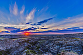 Sunset on August 1, 2015 at the Horsethief Canyon Viewpoint overlooking the Red Deer River, north of Drumheller, Alberta, on the Dinosaur Trail scenic drive. The name comes from the pioneer days when horses would get lost in the Badlands here and then re-emerge found, but with a new brand on them. The region is home to rich deposits of late Cretaceous dinosaur fossils. Just south of here is the world class Royal Tyrrell Museum, a centre of research into dinosaurs and prehistoric life.