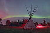 Ein Polarlichtvorhang und der Große Wagen über einem Tipi der Blackfoot Nation, aufgenommen vom Elk Island National Park im September 2006 während der Zeremonie zur Erklärung des Dark Sky Preserve. Eine einzelne kurze Belichtung von 25 Sekunden mit dem 16-mm-Objektiv bei f/3,5 und der Canon 20D bei ISO 400.