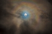 The nearly Full Moon of April 10, 2017 as seen from Australia, and embedded in fast-moving low cloud adding the colourful corona effect around the Moon from water-droplet diffraction.