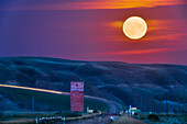 The Full Moon rise of August 11, 2022 over the old grain elevator on Highway 10 at Dorothy, Alberta, in the Badlands of the Red Deer River valley. This was dubbed a "supermoon" and the "Sturgeon Moon" in the popular media. It just happened to rise at a location that placed it right down the south-east facing highway in the valley.