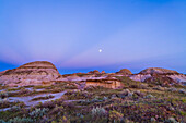 Der zunehmende gibbous Mond über dem blauen Schatten der Erde und dem rosafarbenen Venusgürtel, mit dunkelblauen Dämmerungsstrahlen, die auf den Antisolarpunkt im Osten konvergieren, bei Sonnenuntergang, von den Badlands des Dinosaur Provincial Park, Alberta. Teil einer Zeitraffersequenz mit 450 Bildern, aufgenommen mit der Canon 5D MkII und dem 24-mm-Objektiv am Radian Motion Controller.