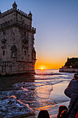 People enjoy a beautiful sunset from Belem Tower or Tower of St Vincent on the bank of the Tagus River, Lisbon, Portugal