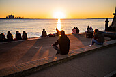 Menschen genießen einen schönen Sonnenuntergang vom Turm von Belem oder dem Turm von St. Vincent am Ufer des Tejo, Lissabon, Portugal