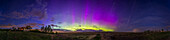 A panorama of the Kp5-level aurora on May 27, 2022, from home, with the aurora displaying prominent magenta rays, created by the red oxygen emission blending with illumination from blue scattered sunlight at high altitudes, common around the summer solstice when the high atmosphere is lit all night long. As a bonus, a dim STEVE arc is forming at far right, to the south of the main auroral oval where STEVE normally appears. STEVE faded, then returned to become more strong and visible across the sky from east to west as the main aurora to the north faded.