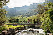 Hikers crossing bridge, Termas de Papallacta, Napo, Ecuador, South America