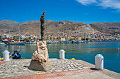View of statue in port town of Kalimnos with hills in the background, Kalimnos, Dodecanese Islands, Greek Islands, Greece, Europe