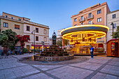 Blick auf Karussell und Springbrunnen auf der Piazza Matteotti in der Abenddämmerung, Olbia, Sardinien, Italien, Mittelmeer, Europa