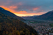 Lärchenwälder auf den Bergen um die Stadt Morbegno bei Sonnenuntergang im Herbst, Valtellina, Provinz Sondrio, Lombardei, Italien, Europa