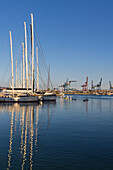 Spanien, Valencia, Segelboote im Yachthafen mit Hafenkränen im Hintergrund