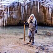 USA, Utah, Springdale, Zion National Park, Ältere Frau überquert Fluss beim Wandern in den Bergen