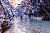 USA, Utah, Springdale, Zion National Park, Ältere Frau überquert Fluss beim Wandern in den Bergen