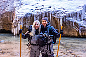 USA, Utah, Springdale, Zion National Park, Älteres Ehepaar überquert Fluss beim Wandern in den Bergen