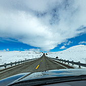 USA, Idaho, Sun Valley, Schnellstraße durch verschneite Landschaft vom Auto aus gesehen