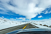 USA, Idaho, Bellevue, Autobahn durch schneebedeckte Landschaft vom Auto aus gesehen