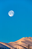 USA, Idaho, Sun Valley, Full moon over snow-covered hills