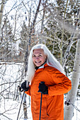 Lächelnde Frau beim Schneeschuhwandern im Winter