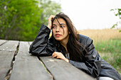 Portrait of teenage girl (16-17) leaning on picnic table