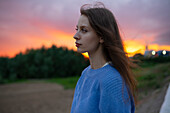 Portrait einer schönen Frau im Feld stehend bei Sonnenuntergang