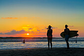 Surfer und Frau fotografieren den Sonnenuntergang mit Smartphone am beliebten Guiones Beach, Playa Guiones, Nosara, Guanacaste, Costa Rica, Mittelamerika