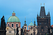 Details von Statuen und Türmen an der Karlsbrücke, mit der Kuppel der Kirche des Heiligen Franz von Assisi und dem Altstädter Brückenturm, UNESCO-Weltkulturerbe, Prag, Böhmen, Tschechische Republik (Tschechien), Europa