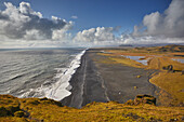 Ein Blick von der Insel Dyrholaey entlang eines riesigen vulkanischen schwarzen Sandstrandes, nahe der Stadt Vik, an der Südküste Islands, Polargebiete