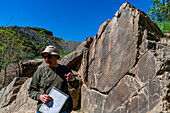 Archäologe zeigt auf Felszeichnungen, Vale de Coa, UNESCO-Welterbestätte, Portugal, Europa