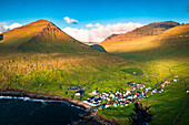 Luftaufnahme des Küstendorfes Gjogv und der Berge bei Sonnenaufgang, Eysturoy Island, Färöer Inseln, Dänemark, Europa