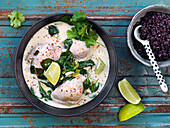 Chicken stew with coconut milk, cilantro, spinach, and lime, served with black rice