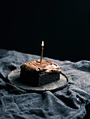 Schokoladenkuchen mit Schokoladen-Frosting und einer Kerze