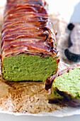 Pea mousse loaf wrapped in crispy bacon baked in the oven