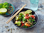 Noodles with salmon, broccoli, lime, pumpkin seeds, herbs, and chili