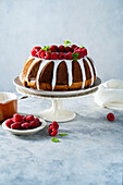 Bundt cake with vanilla frosting and raspberries