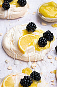 Mini meringues topped with lemon curd and blackberries