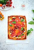 Puff pastry tart with cream cheese, tomatoes, garlic and basil