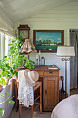 Rustic work area with antique desk and green plants by the window