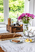 Breakfast table with fresh bread and bouquet of flowers