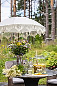 Sommerliche Tischdekoration mit Wildblumen und Limonade im Garten