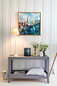 Scandinavian-style console table with decoration and painting with harbour scene