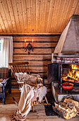 Holzverkleidete Wohnstube mit Kaminfeuer und rustikalem Holzmobiliar