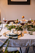 Elegant gedeckter Esstisch mit Weingläsern und Tannenzweigen