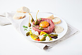 Classic beef tartar with egg yolk and capers