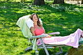 Brünette Frau beim Relaxen im Garten