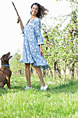 Brünette Frau mit Hund im Garten