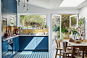Helle Küche im Landhausstil mit blauen Schränken und Essbereich