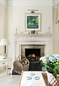 Fireplace area with painting and woven wood basket for firewood