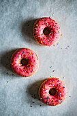 Donuts with pink icing and colored sugar sprinkles