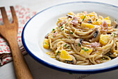 Spaghetti carbonara with mushrooms, ham and pineapple
