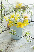 Frühlingsstrauß aus Narzissen (Narcissus) und Schlüsselblumen (Primula veris), Küchenschelle (Pulsatilla) und Obstblütenzweige