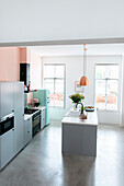 Moderne Küche in Pastellfarben und zentraler Kochinsel